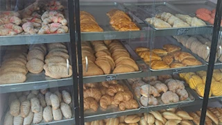 Bakery cases filled with baked goods including cookies, empanadas, and cookies